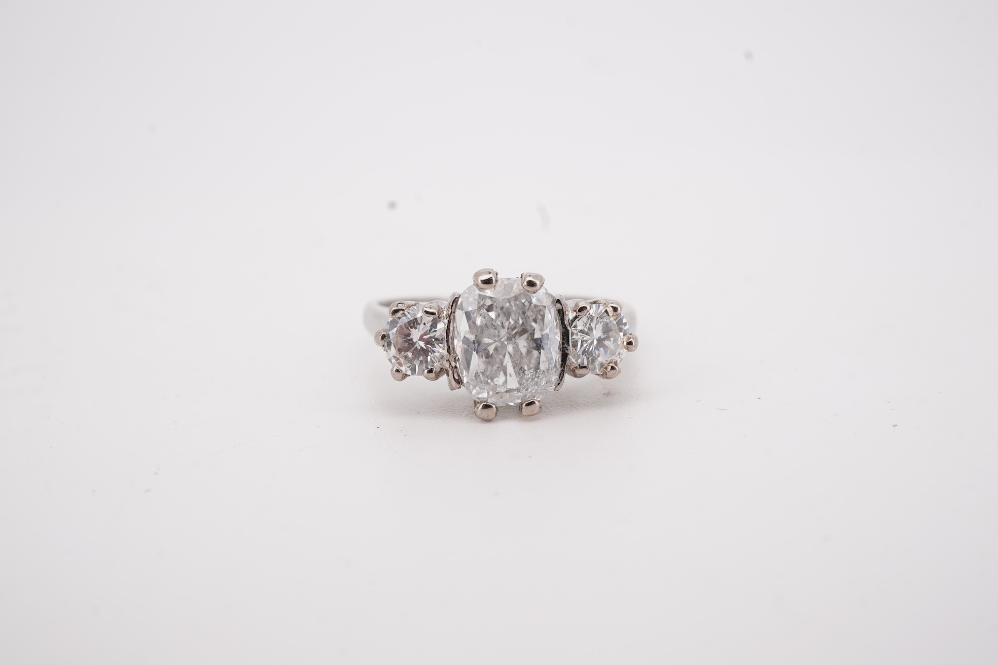 A diamond ring, set with a cushion-shaped diamond weighing 1.50 carats, between shoulders set with brilliant-cut diamonds totalling approximately 0.40 carats, size K, gross weight approximately 4 grams, Condition: centra